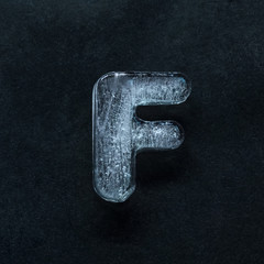 Fototapete - Melting speech. Alphabet's shiny and well-structured letters made out of ice isolated on dark studio background. Collect for combine in words. Copyspace to insert your advertising.