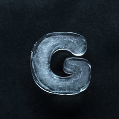 Fototapete - Melting speech. Alphabet's shiny and well-structured letters made out of ice isolated on dark studio background. Collect for combine in words. Copyspace to insert your advertising.