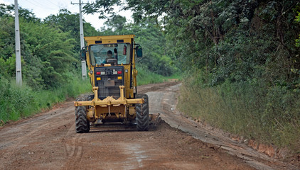 Roadworks machine in Brasil working on gravel road.