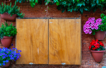 Wall Mural - Old wooden box on a vintage brick wall with flowers in Venice