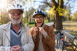 Cheerful active senior couple with bicycle in public park together having fun. Perfect activities for elderly people.