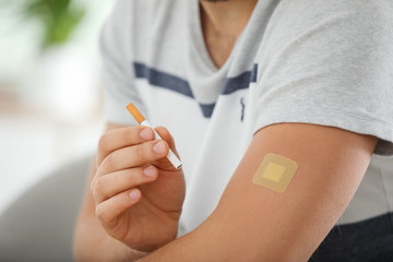 man with nicotine patch and cigarette, closeup