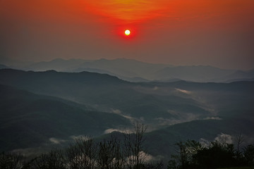 Wall Mural - Sunrise among mountains and fog