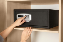 Woman Opening Black Steel Safe With Electronic Lock At Hotel, Closeup