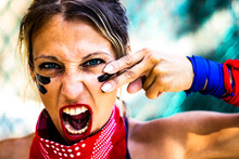 Extreme Close Up Of A Young And Strong Woman With Blue Eyes Preparing To Demonstrate And Protest With A Red Bandana, Looking At Camera And Screaming For Freedom And Human Rights, Revolution,girl Power