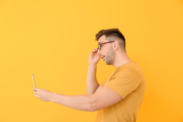 Canvas Print - Handsome man taking selfie on color background