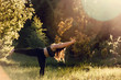 Beautiful plus size girl doing yoga in nature on a sunny summer day.