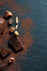 Wall Mural - Aerial view of chocolate, nuts and cocoa on slate plate