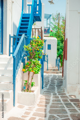 Cuadros en Lienzo The narrow streets of the island with blue balconies, stairs and flowers