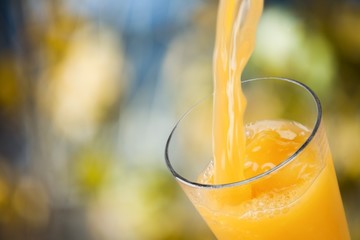 Canvas Print - Orange juice glass on blur background