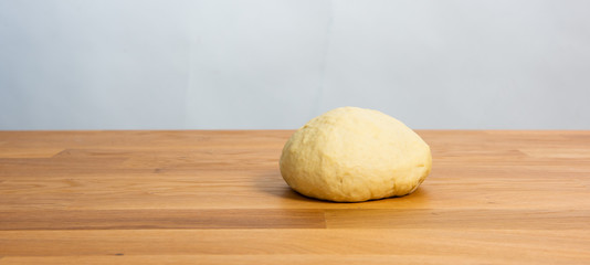 Wheat dough rising on a wooden table