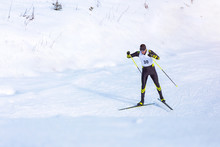 A Man Cross-country Skiing On Trail. Guy With Modern Ski Equipment And Race Number