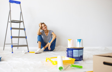 Wall Mural - Repair in apartment. Happy young woman paints wall .