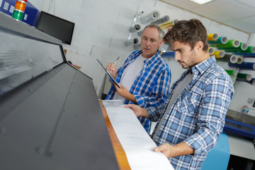 two men looking down at professional printer