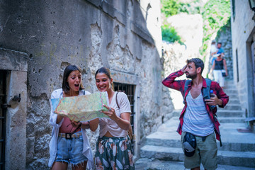 Wall Mural - Young friends in old town using map