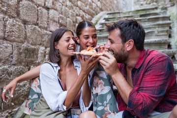 Wall Mural - Happy friends eating pizza at vacation