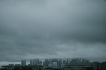 Tall city buildings being covered by clouds on cloudy day in Houston, Texas 