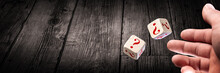 Hand Throwing Two Dice With Red Question Marks Onto Wooden Table
