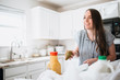 © MeganBetteridge - Lifestyle of women unloading her groceries at home in a white kitchen