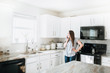 © MeganBetteridge - Lifestyle of Women using Cell Phone in White Kitchen