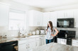 © MeganBetteridge - Lifestyle of Women using Cell Phone in White Kitchen