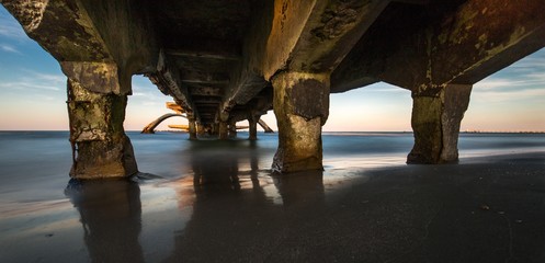 Wide shot of an old broken bridge over the sea