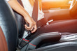 Asian woman fastening seat belt in the car, safety concept