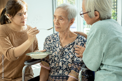 Fotomural Asian woman feeding tired senior patient,anorexia,eat less food,depressed female