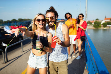 Wall Mural - Group of happy friends hanging out and enjoying drinks, festival