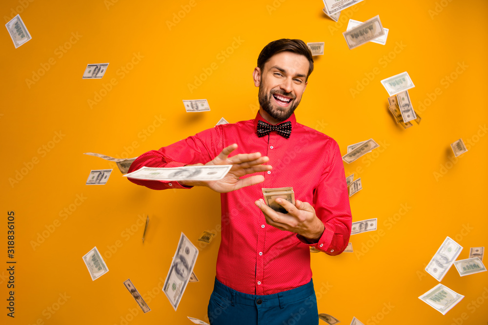 Photo of crazy funny guy hold fan of money bucks waste jackpot throw away banknotes money falling wear trendy red shirt bow tie clothes isolated yellow color background - obrazy, fototapety, plakaty 