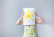 © Angelina - little girl holding a drawing of the sun on a white background