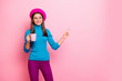 © deagreez - Portrait of positive french girl travel trip point index finger copy space show cafe cafeteria sales promotion hold cup latte ads wear blue trousers isolated over pink color background