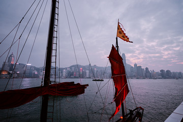 Traditional wooden sailboat sailing in Victoria harbor, Hong Kong.