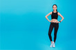 © bunditinay - Portrait of confident beautiful asian fitness woman standing after exercise isolated on blue color background with copy space.Concept of slim and healthy happy girl workout.