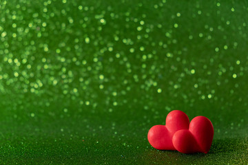 Bright red hearts abstract green bokeh background. Valentines day texture..