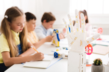 Poster - Children learning in class with humanoid robotic hand on foreground