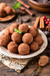 © Vladislav Noseek - Pile of homemade chocolate truffles rolled in cocoa powder on plate on a wooden table. Tasty sweet dessert. Raw chocolate truffles, vegan chocolate