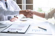 © Ngampol - Finishing up a conversation after collaboration, handshake of two business people after success good deal contract negotiation agreement to become a partner, collaborative teamwork