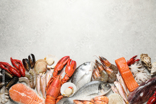 Fotomural Fresh fish and seafood on marble table, flat lay. Space for text
