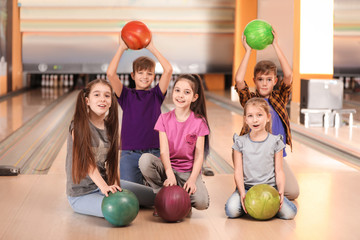 Wall Mural - Happy children with balls in bowling club