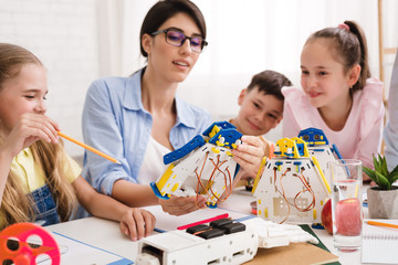 Poster - Pupils and teacher constructing robots together in class