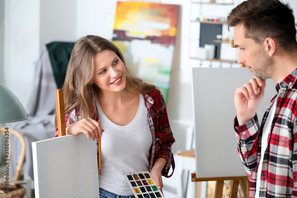 Couple of young artists working in studio
