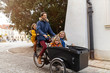 © pikselstock - Young family riding in a cargo bicycle during Christmas