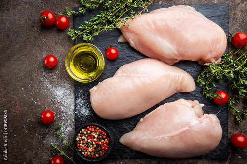 Fotografía Fresh raw chicken breast with herbs and spices, top view