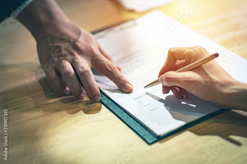Cuadros en Lienzo Closeup female hand signing a contract investment professional document agreement on the table with pen