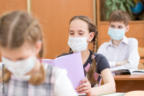 Cuadros en Lienzo Pupils wearing protection mask to prevent virus during lesson in classroom in sc