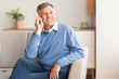© Prostock-studio - Old Man Talking On Cellphone Sitting On Sofa At Home