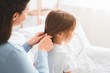 © Prostock-studio - Close up of woman braiding her little daughter hair