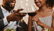 © Prostock-studio - Close up of african couple toasting with red wine