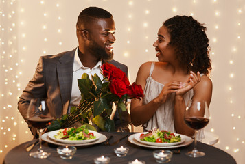 Wall Mural - Afro guy in love giving roses to his surprised girlfriend